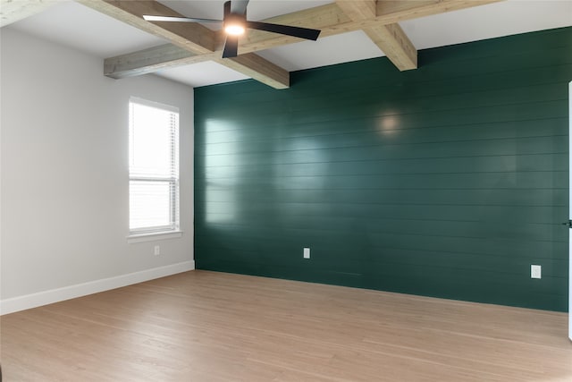 empty room with wood walls, ceiling fan, beam ceiling, and light hardwood / wood-style flooring