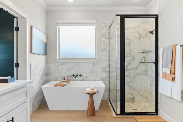 bathroom with ornamental molding, vanity, wood-type flooring, tile walls, and plus walk in shower