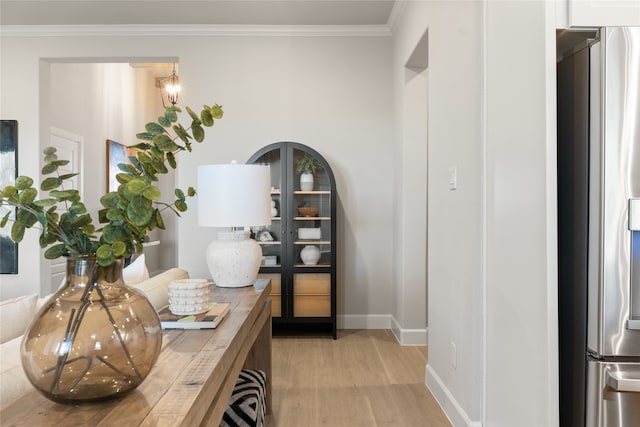 home office with crown molding and light hardwood / wood-style flooring