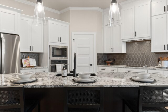 kitchen with white cabinets, pendant lighting, and appliances with stainless steel finishes