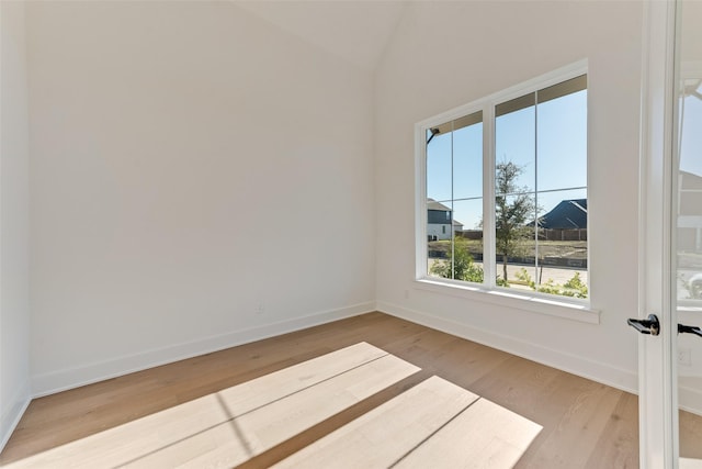 empty room featuring light hardwood / wood-style floors and vaulted ceiling