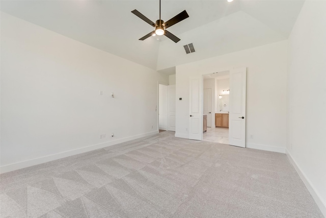 unfurnished bedroom featuring ensuite bath, ceiling fan, high vaulted ceiling, and light colored carpet