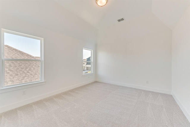 empty room with light carpet and lofted ceiling