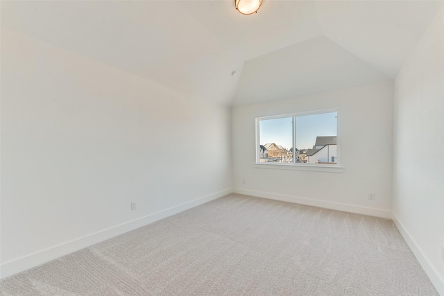 carpeted spare room featuring lofted ceiling