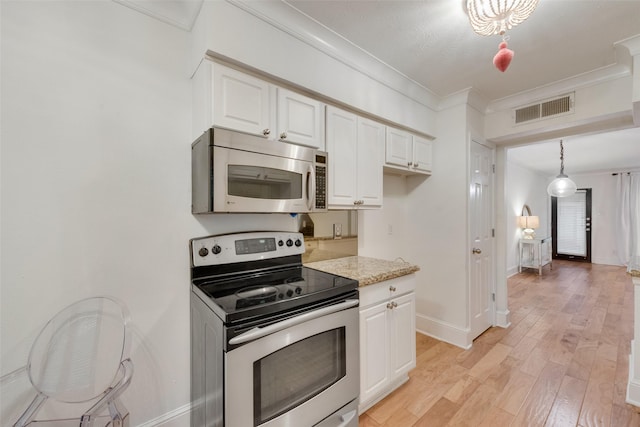 kitchen with appliances with stainless steel finishes, crown molding, hanging light fixtures, and white cabinetry