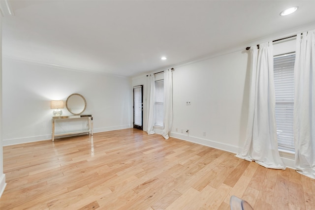 spare room featuring ornamental molding and light hardwood / wood-style floors