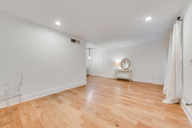 empty room featuring crown molding and light hardwood / wood-style flooring