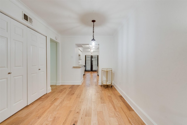 corridor with hardwood / wood-style flooring and crown molding