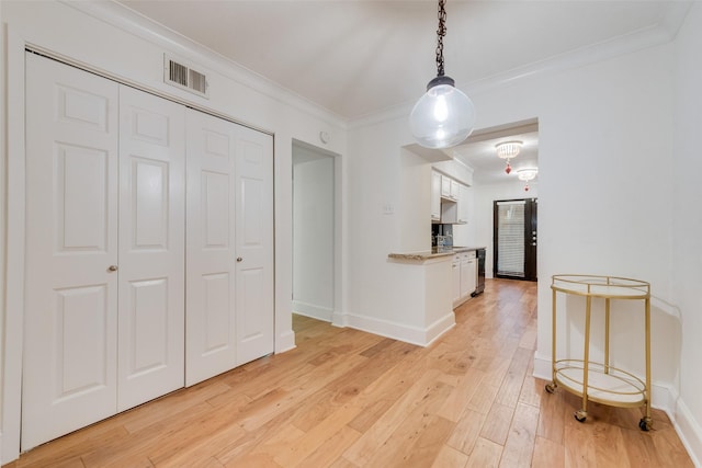 interior space featuring light hardwood / wood-style floors and crown molding