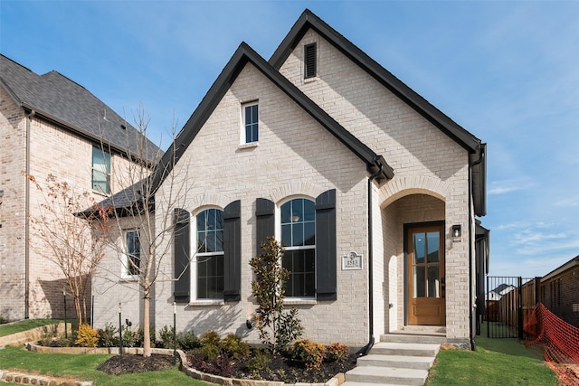 french country inspired facade featuring a front yard