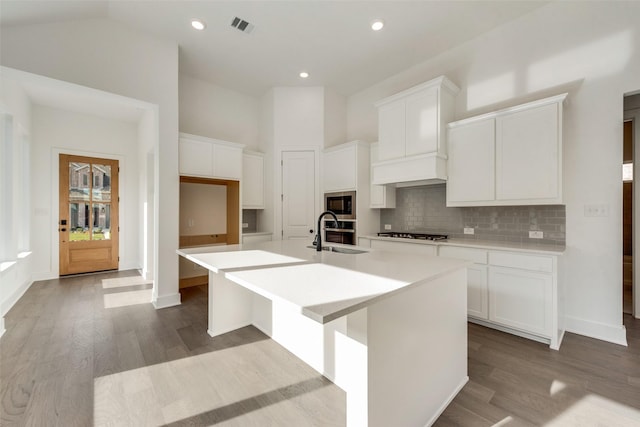 kitchen featuring a kitchen island with sink, white cabinets, and light hardwood / wood-style floors