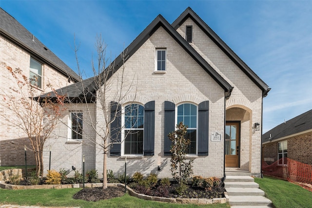 french country inspired facade featuring a front lawn