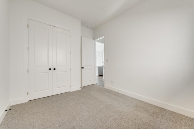 unfurnished bedroom featuring light carpet and a closet