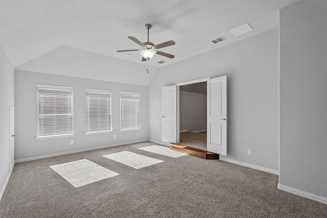 unfurnished bedroom with vaulted ceiling, carpet, visible vents, and baseboards