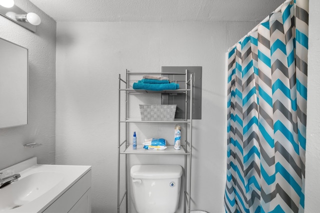 bathroom featuring vanity, a shower with shower curtain, a textured ceiling, and toilet