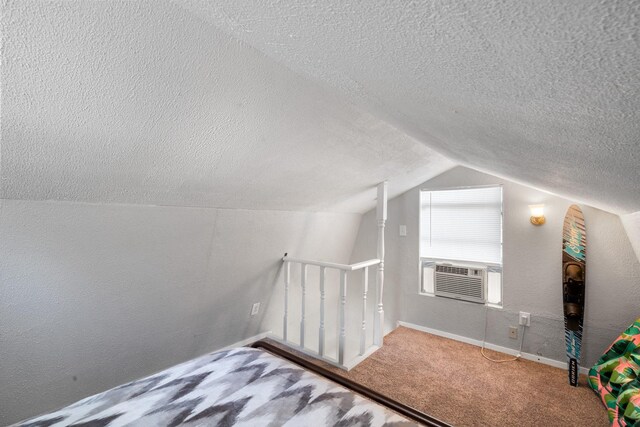 unfurnished bedroom with carpet flooring, a textured ceiling, cooling unit, and lofted ceiling