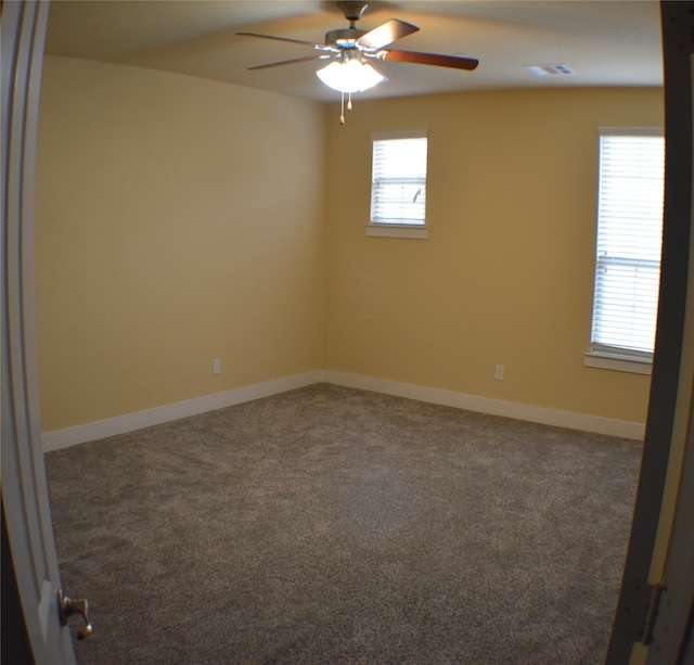 empty room with dark carpet and ceiling fan