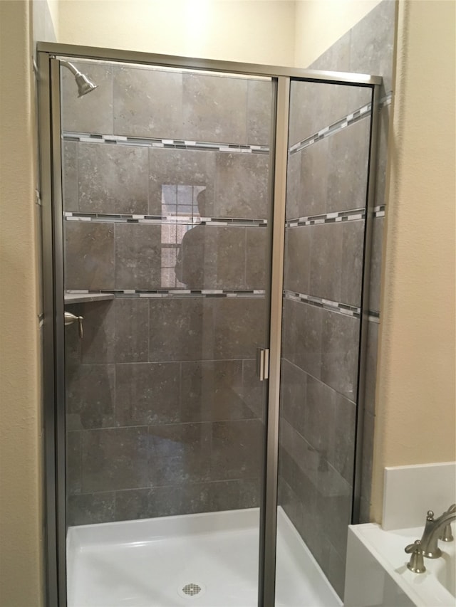 bathroom featuring a shower with shower door