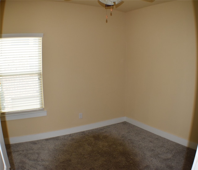 carpeted spare room with ceiling fan