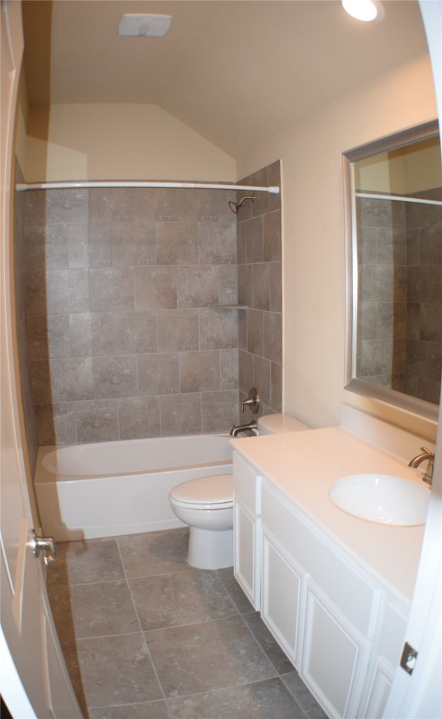 full bathroom featuring tile patterned floors, vanity, toilet, tiled shower / bath, and lofted ceiling