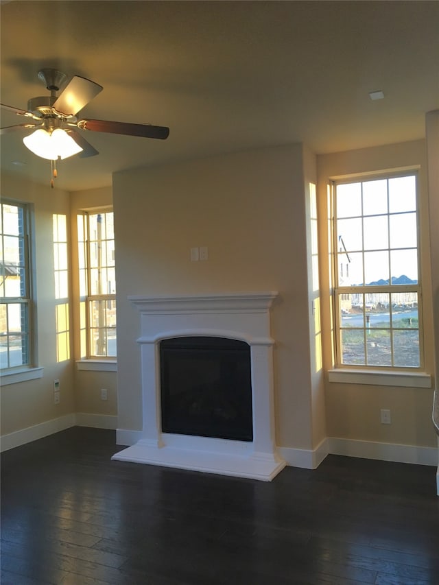 unfurnished living room featuring dark hardwood / wood-style flooring, plenty of natural light, and ceiling fan