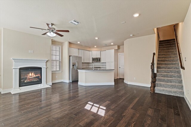 kitchen with dark hardwood / wood-style flooring, tasteful backsplash, a kitchen island with sink, sink, and white cabinets