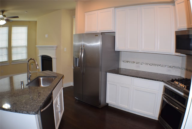 kitchen with dark stone countertops, white cabinetry, and stainless steel appliances