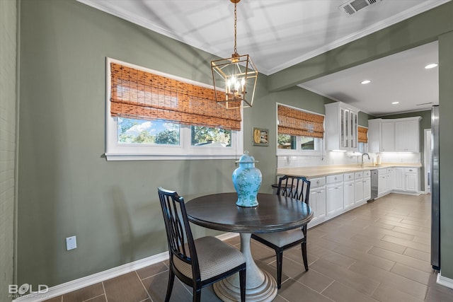 dining space with crown molding and an inviting chandelier