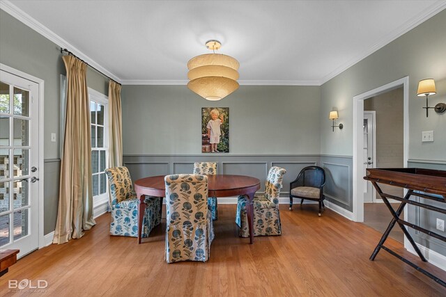 dining room featuring light hardwood / wood-style floors and crown molding