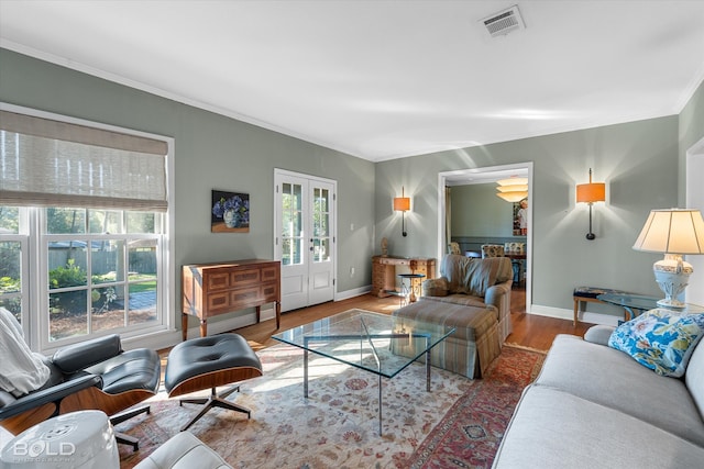 living room featuring french doors, ornamental molding, and hardwood / wood-style flooring