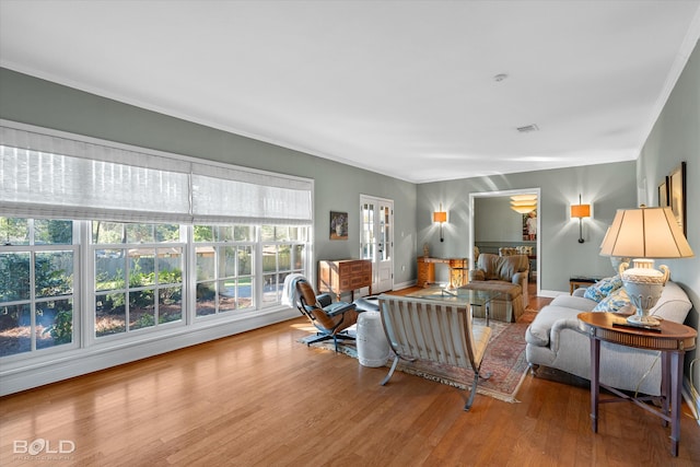 living room with light hardwood / wood-style floors and ornamental molding