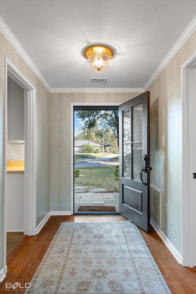 foyer featuring crown molding, wood-type flooring, and a textured ceiling