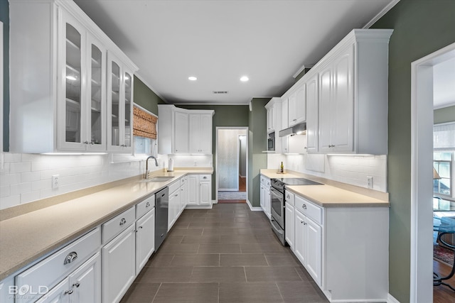 kitchen featuring white cabinets, appliances with stainless steel finishes, tasteful backsplash, and sink