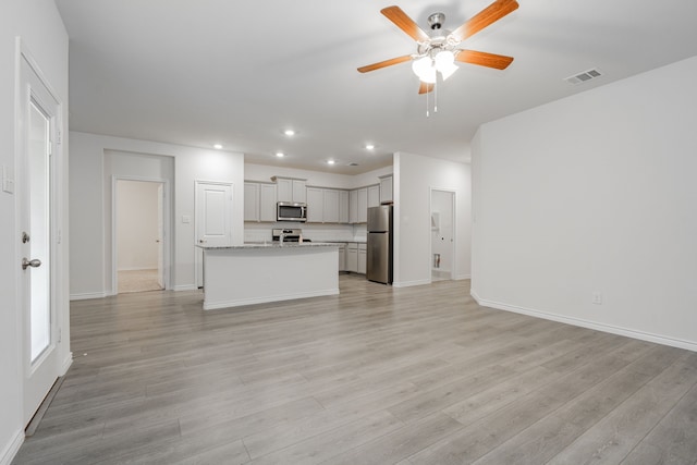 unfurnished living room with ceiling fan and light hardwood / wood-style floors