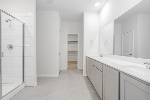 bathroom featuring tile patterned floors, vanity, and a shower with shower door