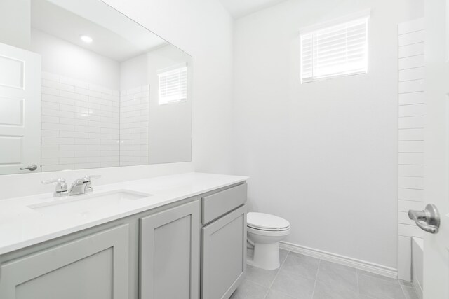 bathroom with tile patterned flooring, vanity, and toilet