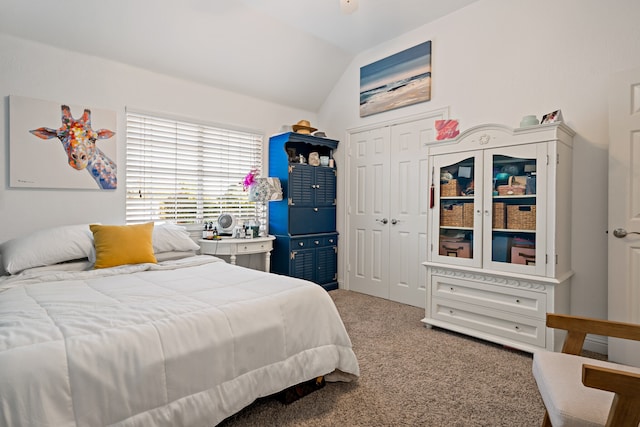 carpeted bedroom with a closet and vaulted ceiling