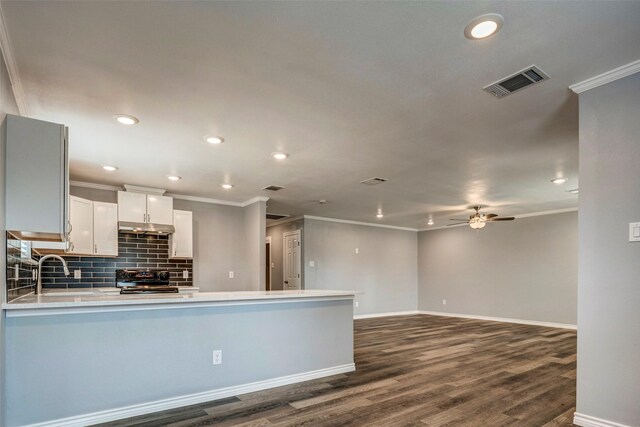 kitchen with white cabinets, black range, dark hardwood / wood-style flooring, and kitchen peninsula