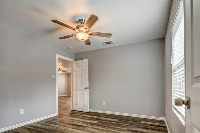 empty room with dark hardwood / wood-style flooring and ceiling fan