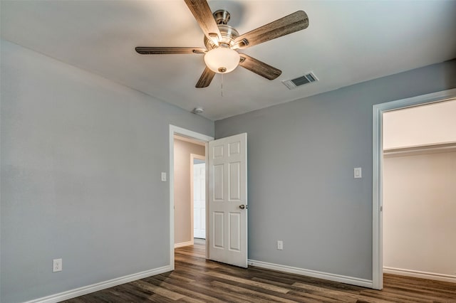 unfurnished bedroom featuring ceiling fan, dark wood-type flooring, and a closet