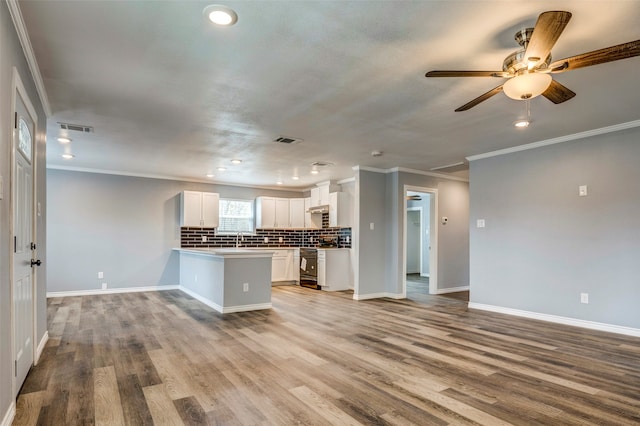 kitchen with white cabinets, sink, tasteful backsplash, light hardwood / wood-style floors, and kitchen peninsula