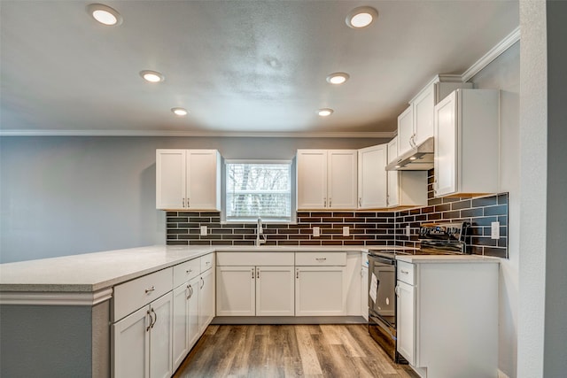 kitchen with kitchen peninsula, light wood-type flooring, crown molding, white cabinets, and black range with electric stovetop