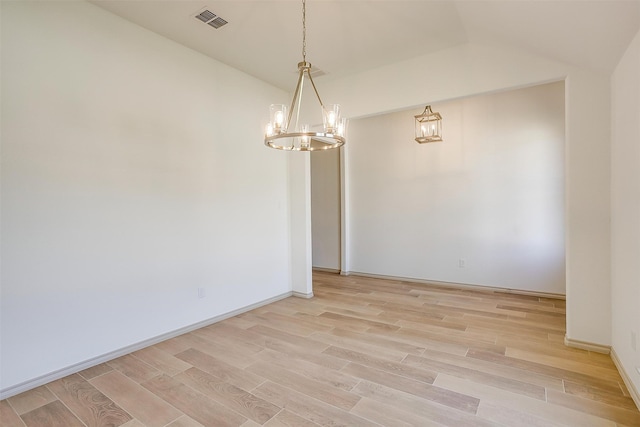 empty room featuring light hardwood / wood-style floors and vaulted ceiling