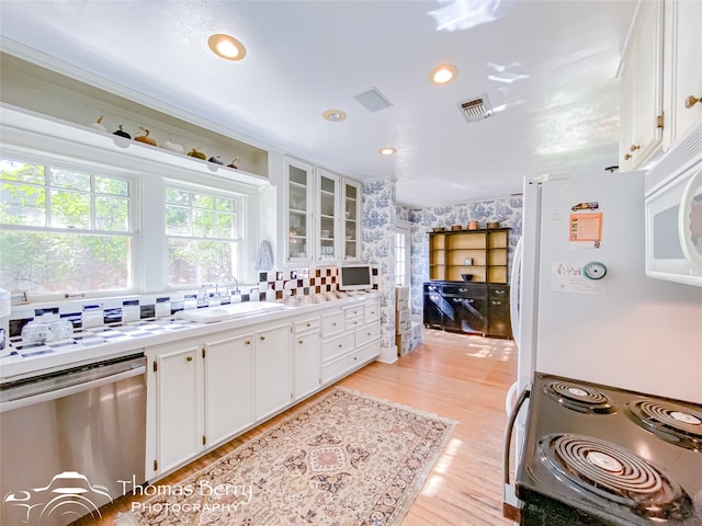 kitchen featuring dishwasher, white cabinets, range with electric cooktop, sink, and light wood-type flooring