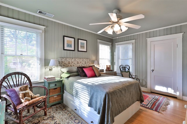 bedroom featuring ceiling fan, light hardwood / wood-style floors, and crown molding