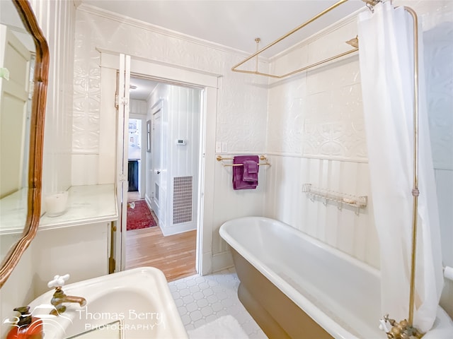 bathroom with hardwood / wood-style flooring, shower / bathtub combination with curtain, and ornamental molding