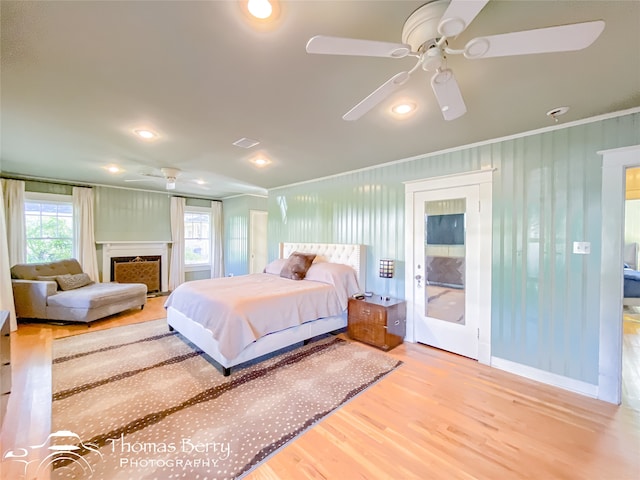 bedroom with wood-type flooring, ceiling fan, and ornamental molding