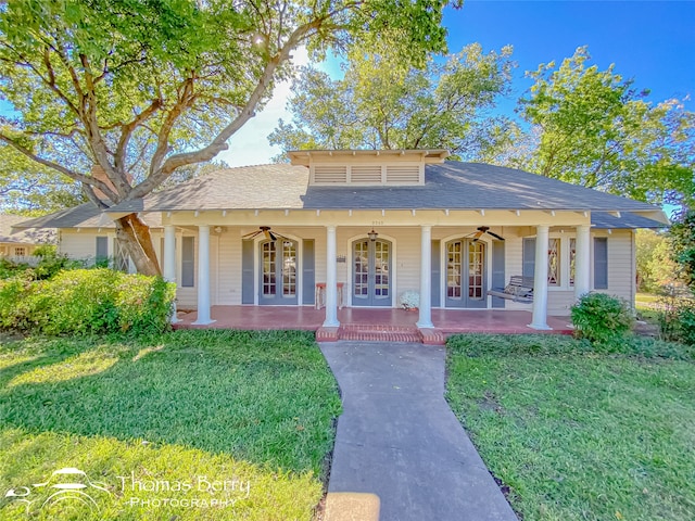 view of front of home with ceiling fan, a front yard, and french doors