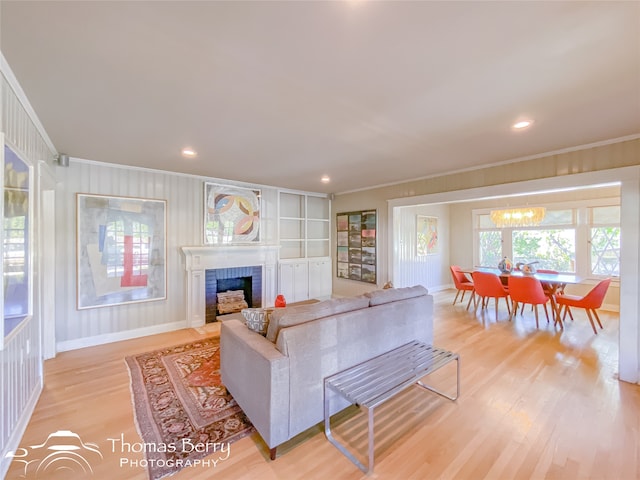 living room with a chandelier, crown molding, and light hardwood / wood-style floors