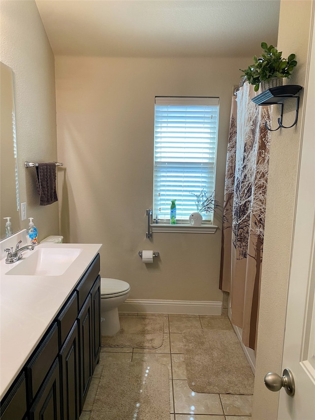 bathroom featuring tile patterned flooring, vanity, and toilet